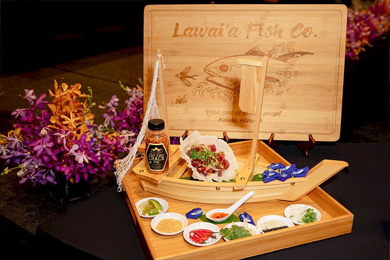 A wooden display for Laveria Fresh Co. with a bottle, salad, and several small condiment dishes on plates.